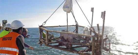Barco con una grua bajando un robot submarino al agua