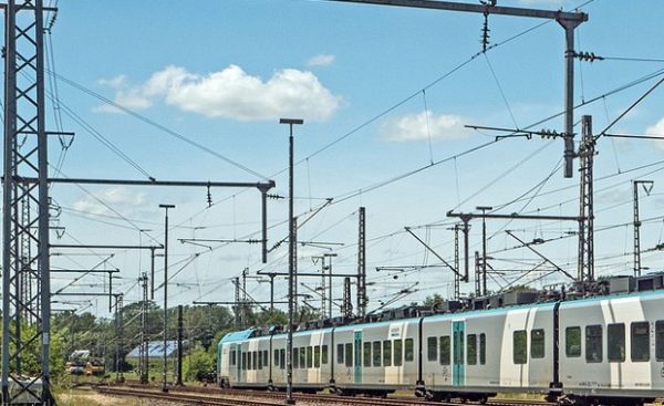 Catenaria de una via ferroviaria y tren circulando