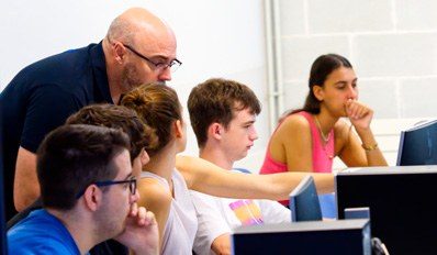 Profesor y alumnos en aula informática